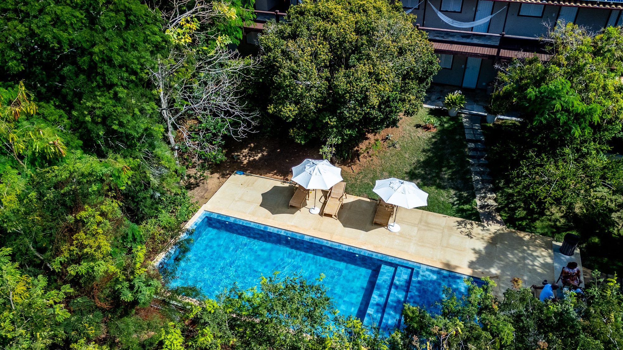 Vista aérea da piscina da Pousada Vila Pitanga cercada de mata nativa em Búzios